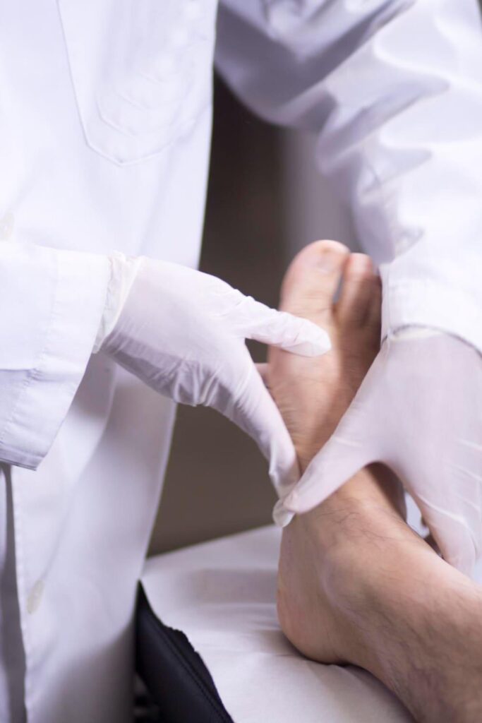 Doctor examining a patient's foot and big toe during bunion surgery recovery
