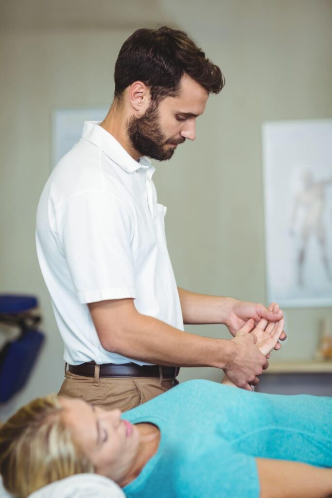 Hand therapist examining a patient's wrist during carpal tunnel surgery recovery
